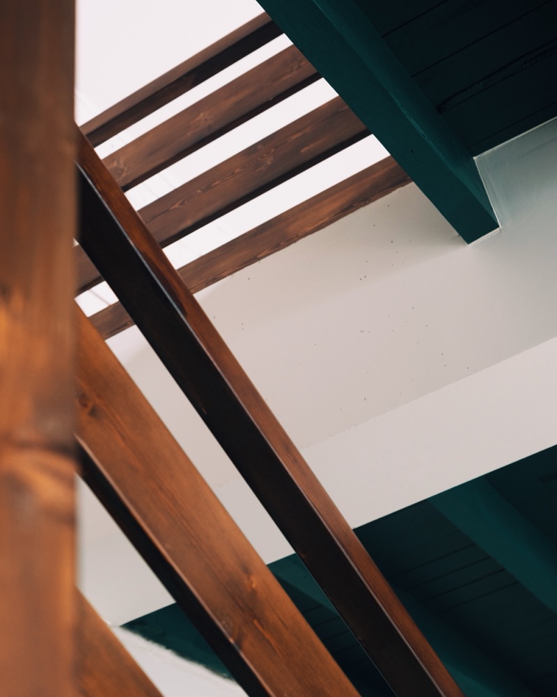 L'escalier en bois sombre de La Grange, sous le plafond peint en vert.